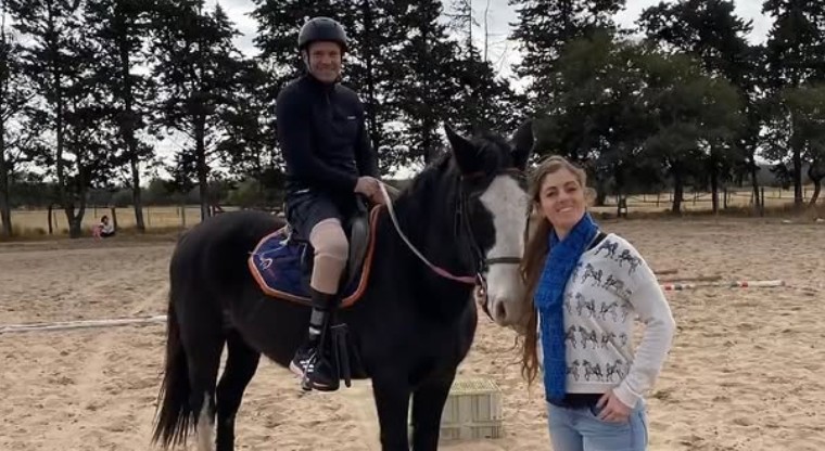 Jinete a caballo junto a instructora, trabajo en equipo durante sesión